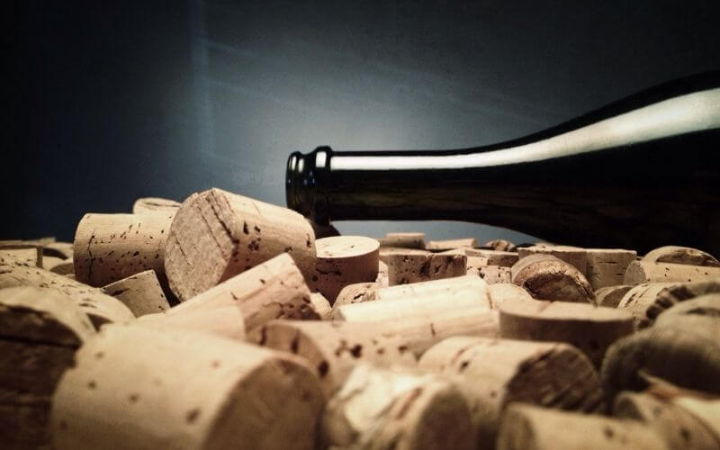 Wine corks with a bottle of wine in a dark background