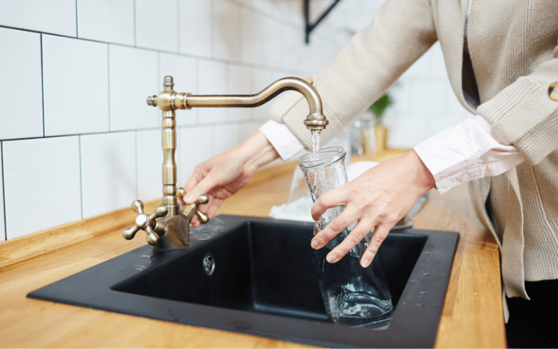 Woman pouring water in a faucet