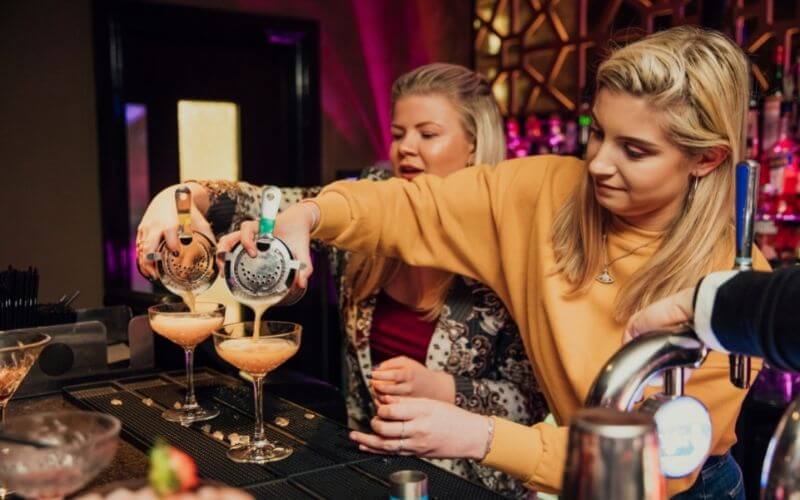 Women training pouring drinks