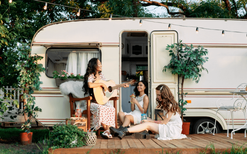 Young Happy Women Have Fun Together Enjoy Picnic near RV
