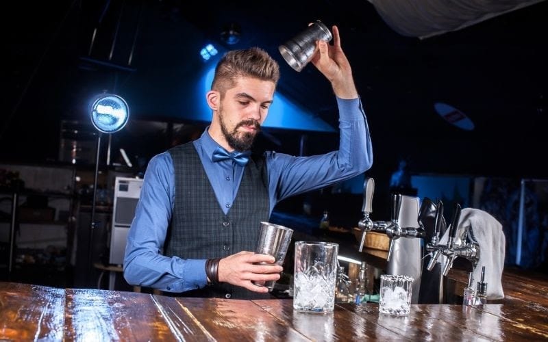 A bartender holding a cocktail shakers