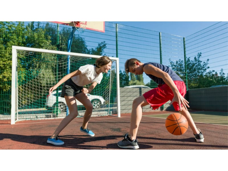 a boy and a girl playing basketball