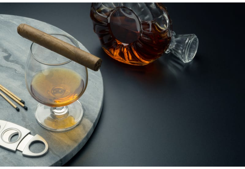a Cuban cigar on a snifter glass of brandy