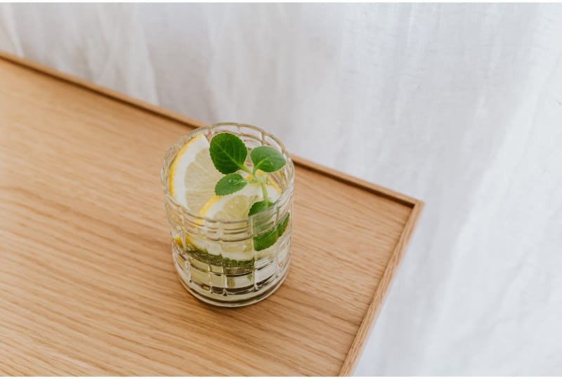 A glass of sparkling lemonade with basil garnish