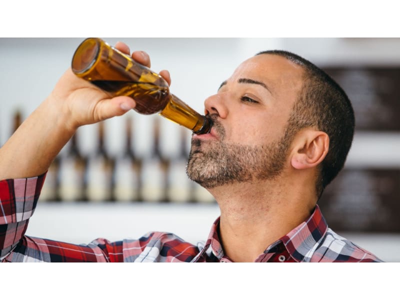 A man drinking a bottle of beer