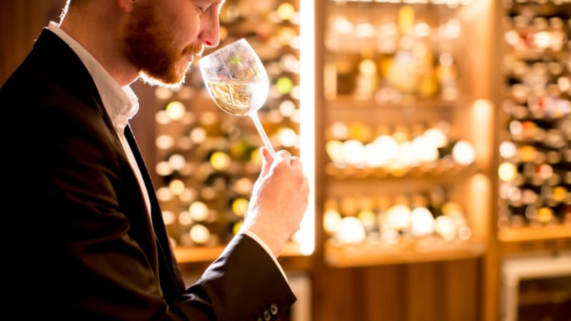 A man sniffing a glass of wine