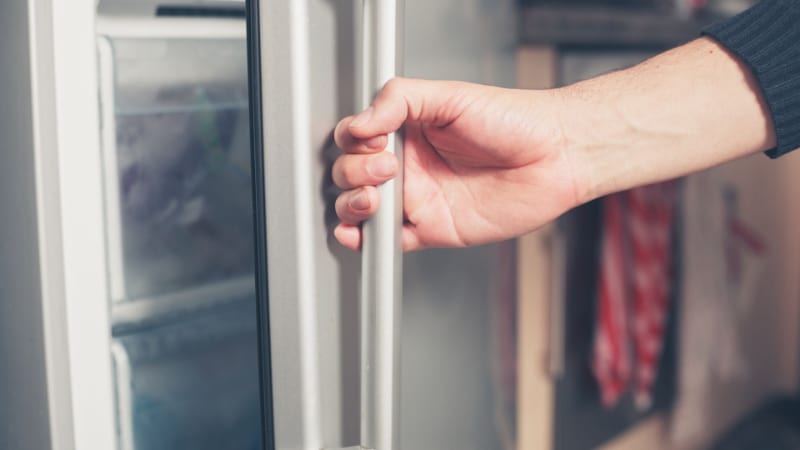 A person opening a freezer