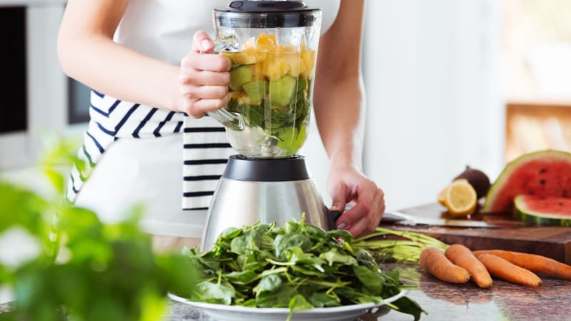 A person using a countertop blender