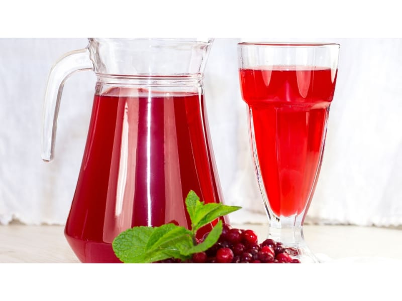 A pitcher and glass of cranberry juice