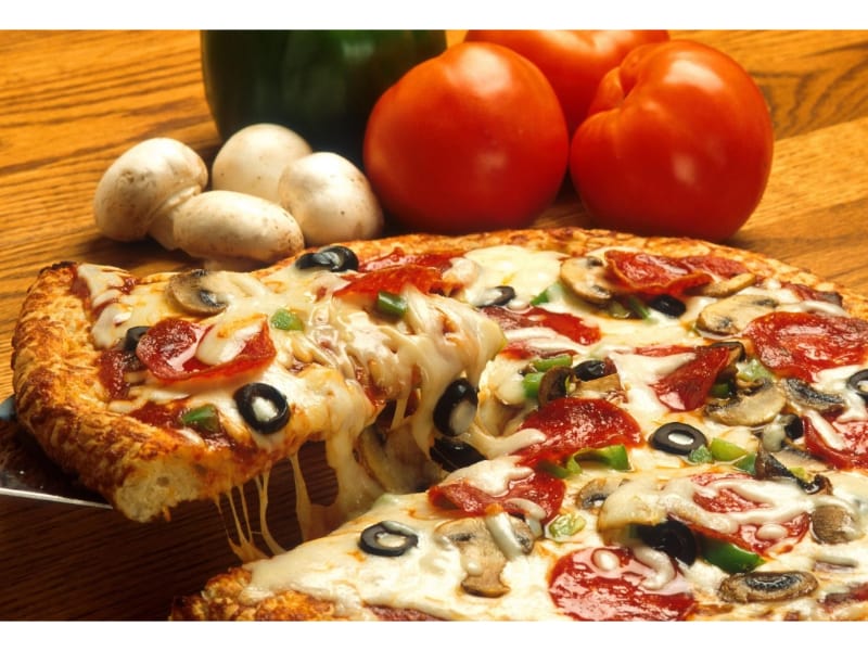 A serving of pizza with tomatoes and mushrooms