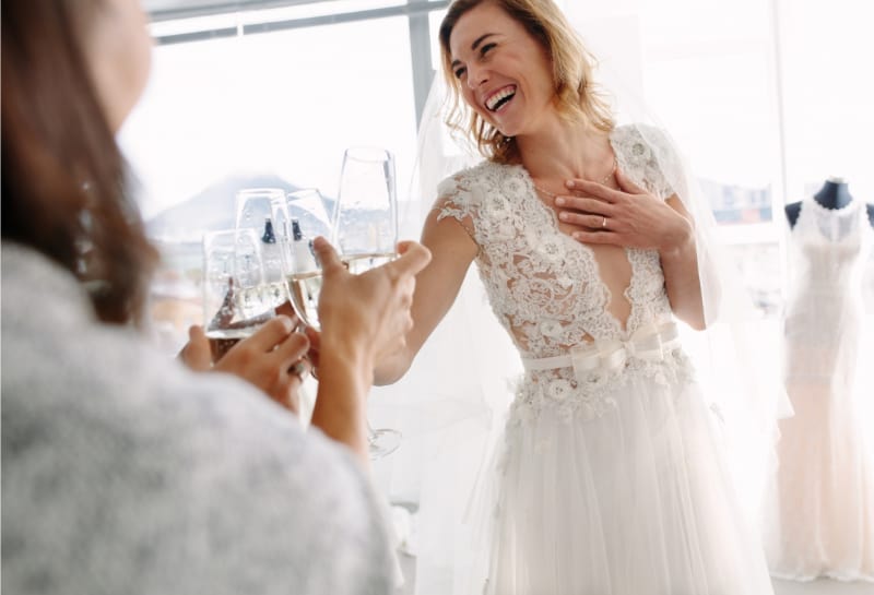 Bride Toasting Champagne with Friends in Bridal Boutique