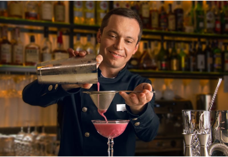 Charming bartender prepares a delicious cocktail