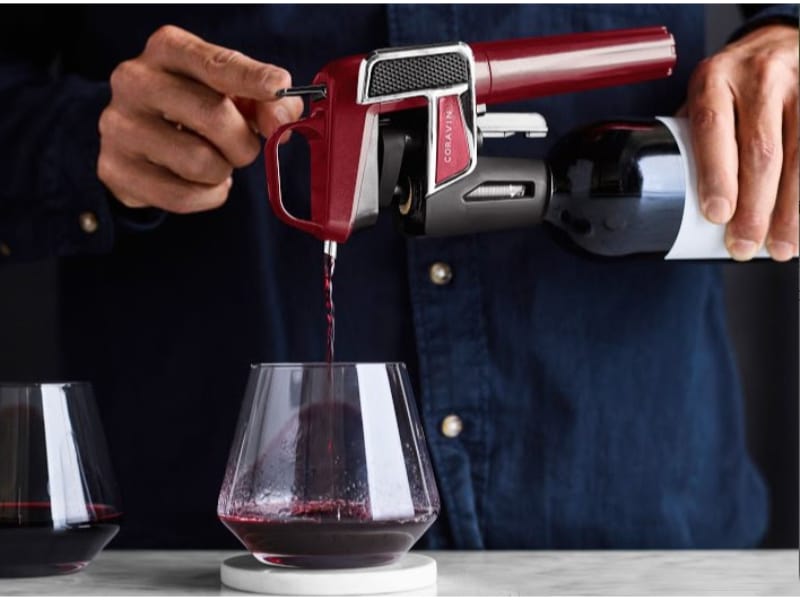 Man pours a wine on a wine glass using Coravin wine preservation system