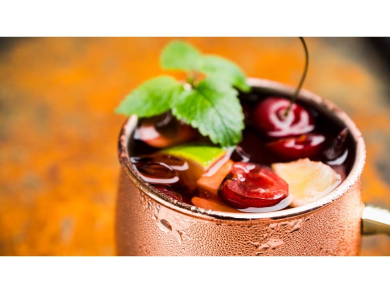 Cuba libre with cherry and mint in a copper mug