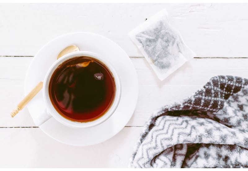 Cup of tea with a teabag on a wooden table