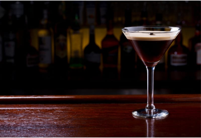 Espresso Martini Cocktail on a bar desk in black background