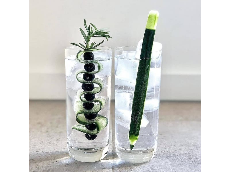 Glasses of G&T cocktail with a cucumber garnish