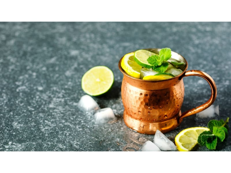 Gin and tonic in a copper mug with lemon and lime on top
