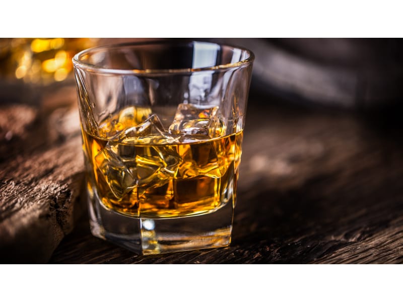 Glass of whiskey on a wooden surface