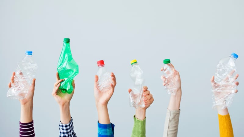 Hands holding up plastic bottles 