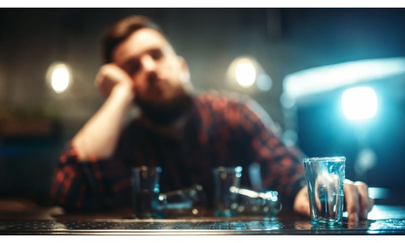 Man drinking at a bar with a shot glass
