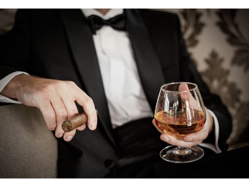 Man holding stemmed whiskey glass