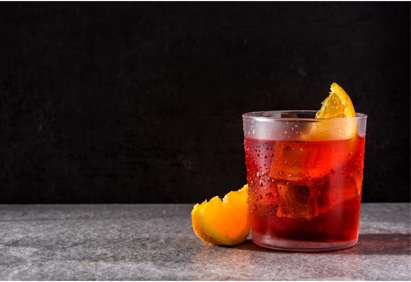 Negroni cocktail with orange on black background