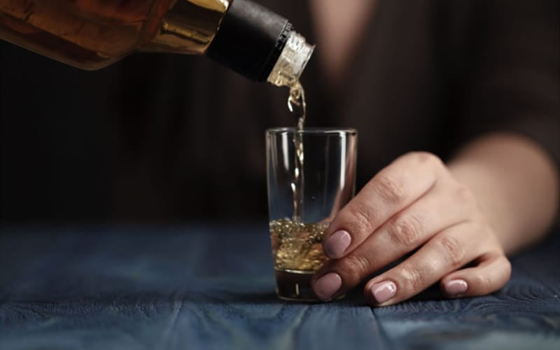 Pouring whiskey into glass shot