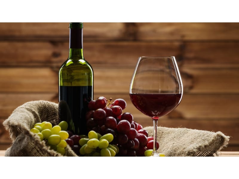 Red wine glass with bottle and grapes