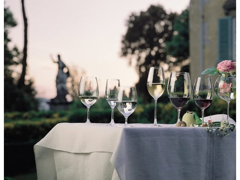 Various wine glasses on a table for an outdoor event.