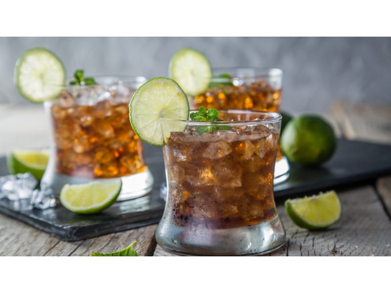 Rum cocktail with ice and lime wheel garnish