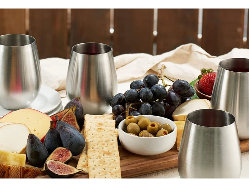 Stainless steel wine glasses with crackers and grapes picnic outdoors