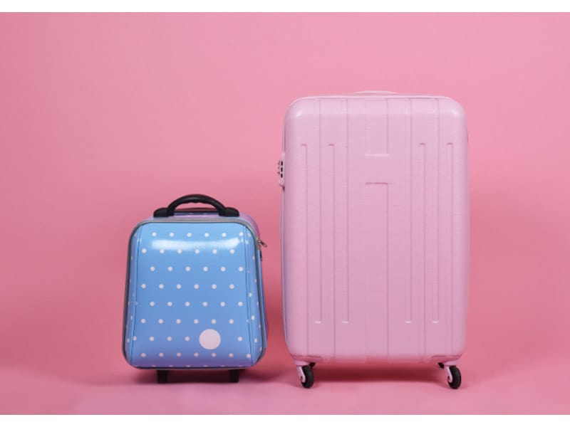 Small blue suitcase with a large pink suitcase