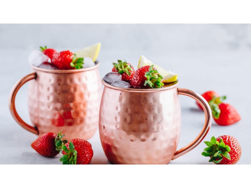 Sweet surrender cocktail with fresh strawberries in a copper mug