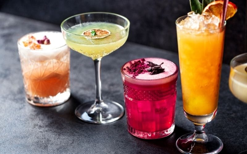 Tasty colored cocktails with various garnishes