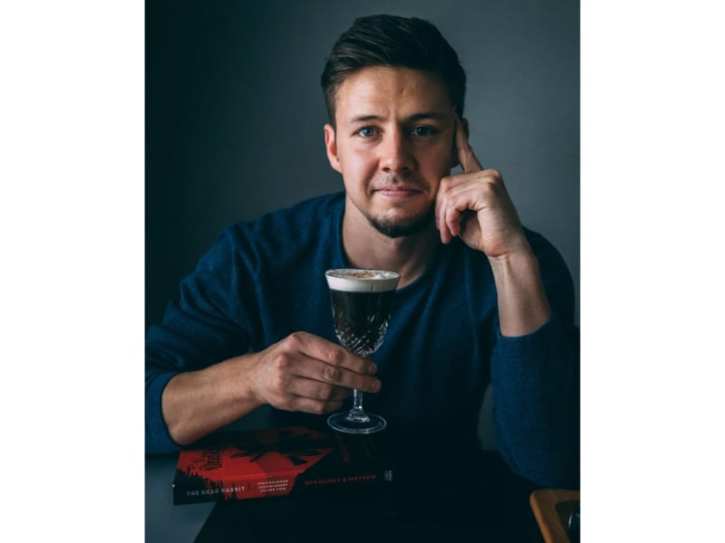 Tyler Zielinski holding a glass of cocktail