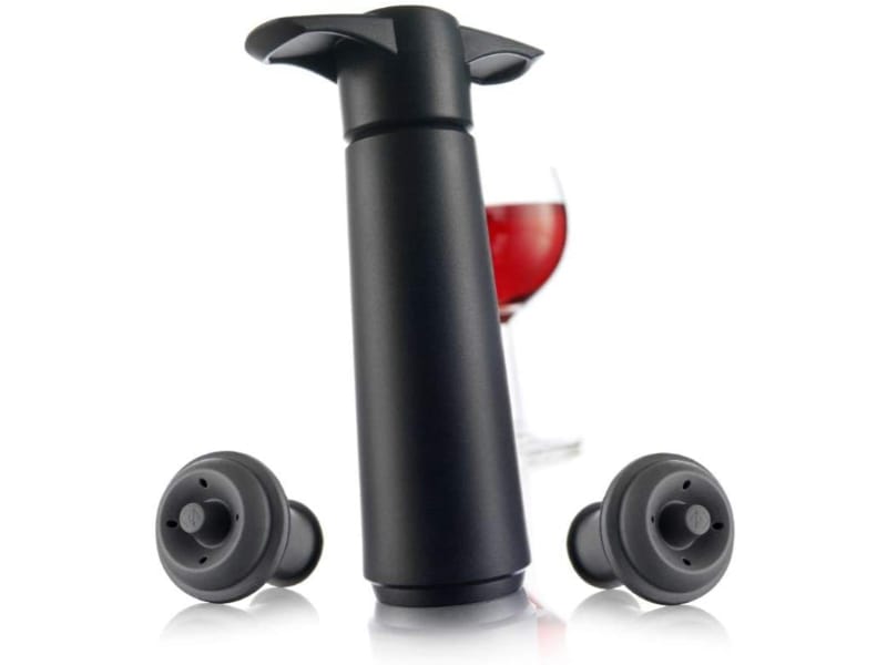 Vacu Vin Pump with 2 stoppers and a glass of red wine behind