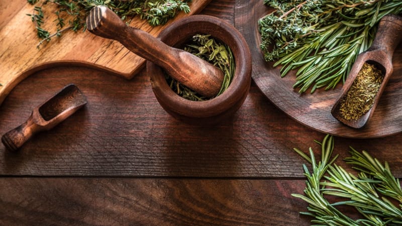 Various aromatic herbs with mortar and pestle