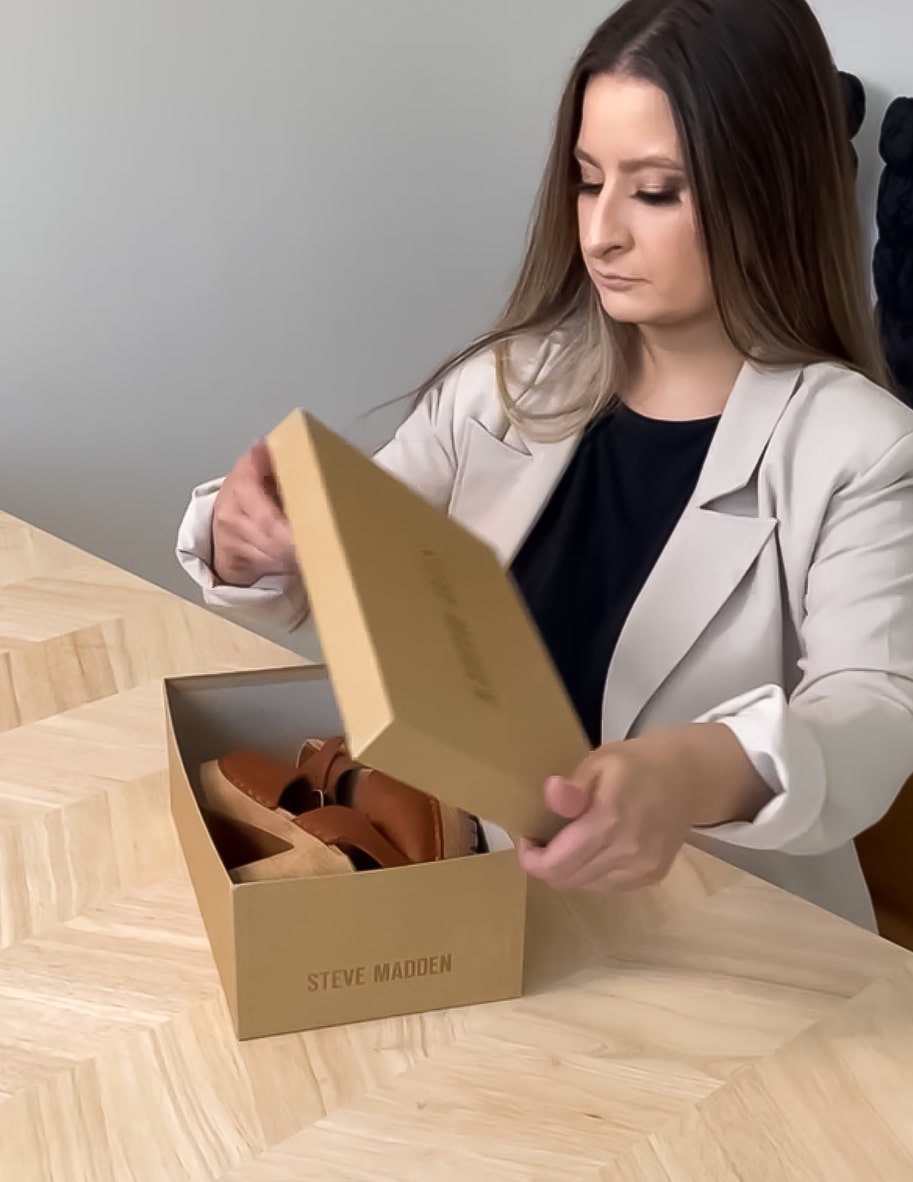 brunette putting brown clogs in shoe box