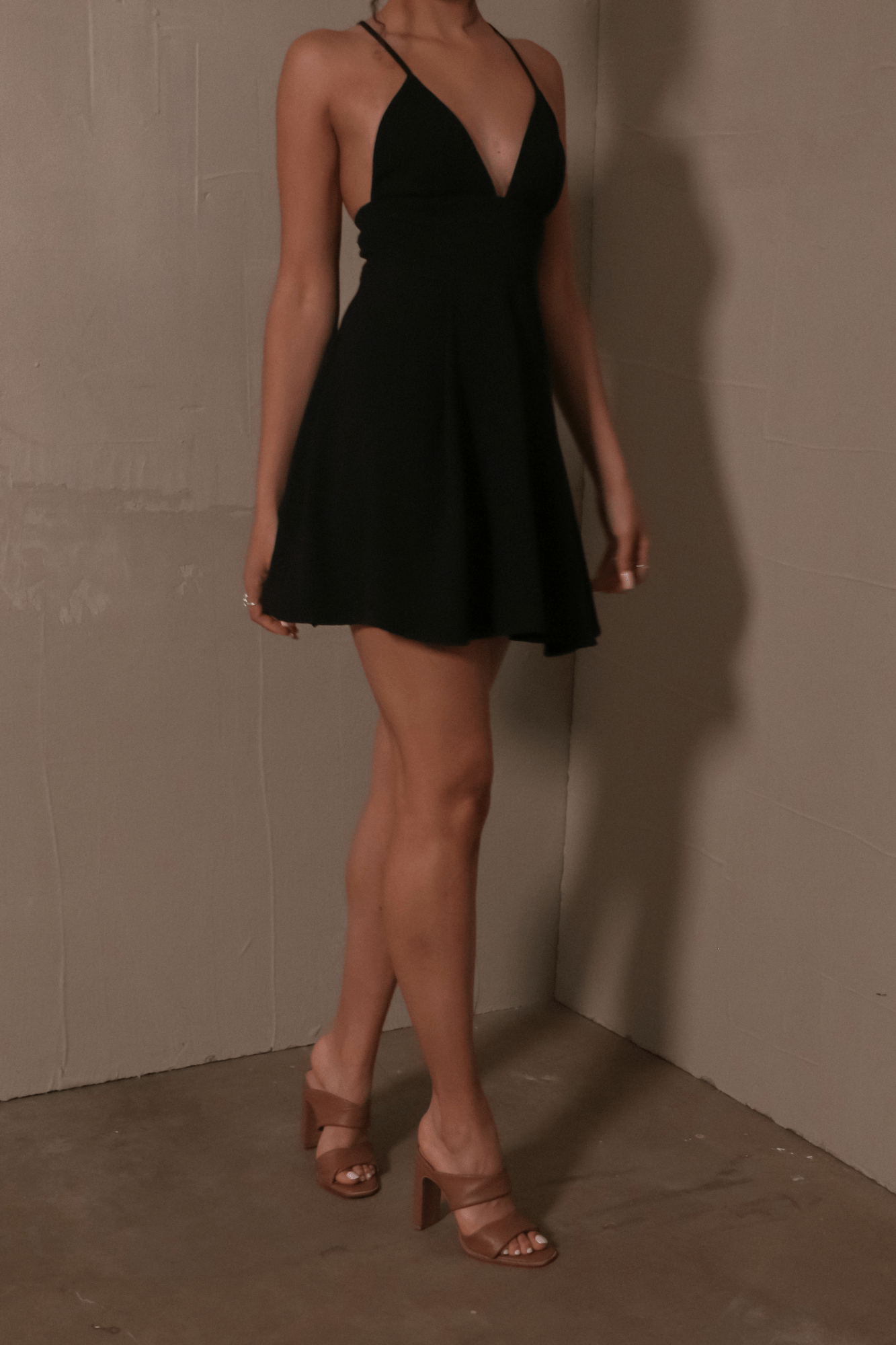 model standing in black lbd and tan 42 gold state of luxe heels