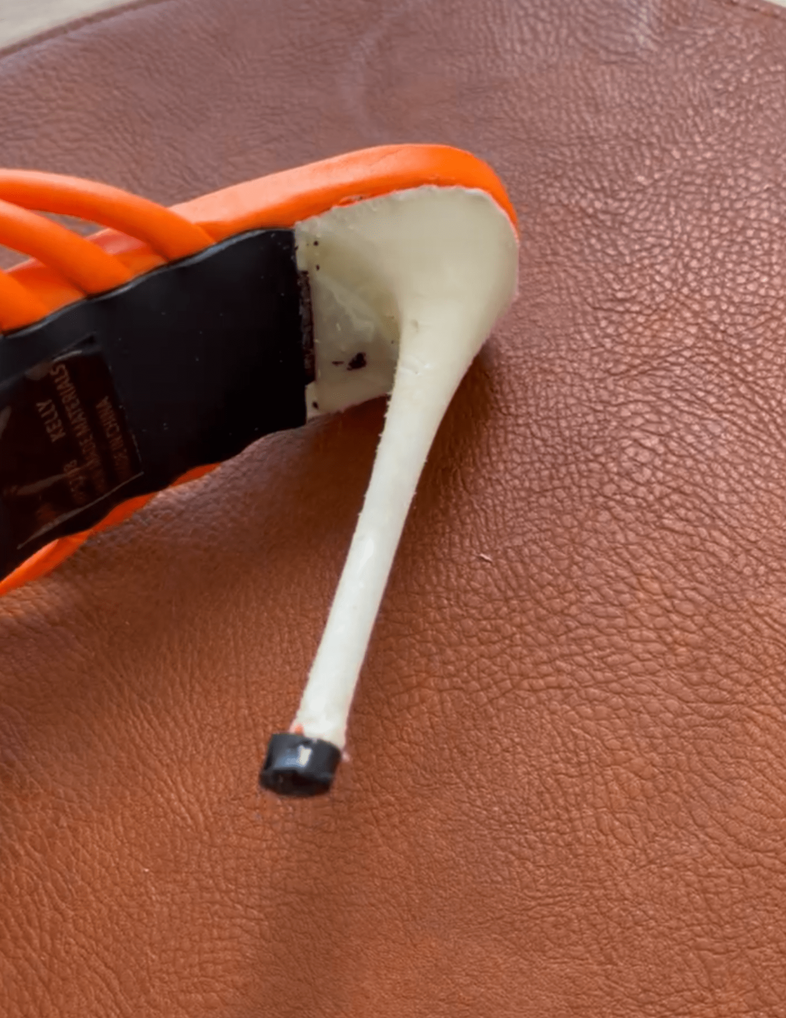 Uncovered stiletto heel on tan mat