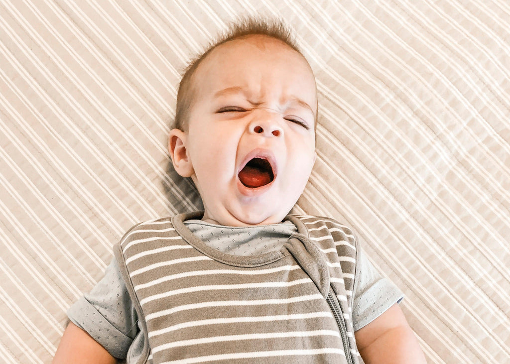 A guide to your baby's sleep patterns blog image of baby yawning in a Woolino sleep bag