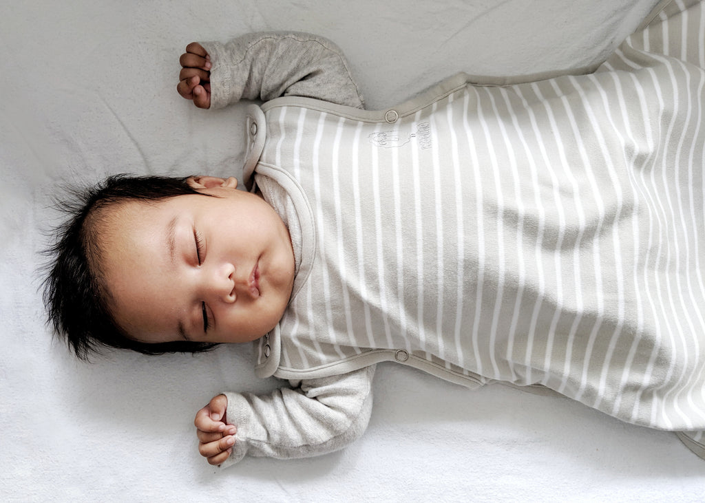 Baby sleeping on back in a Woolino 4 Season Merino Wool Ultimate Baby Sleep Sack