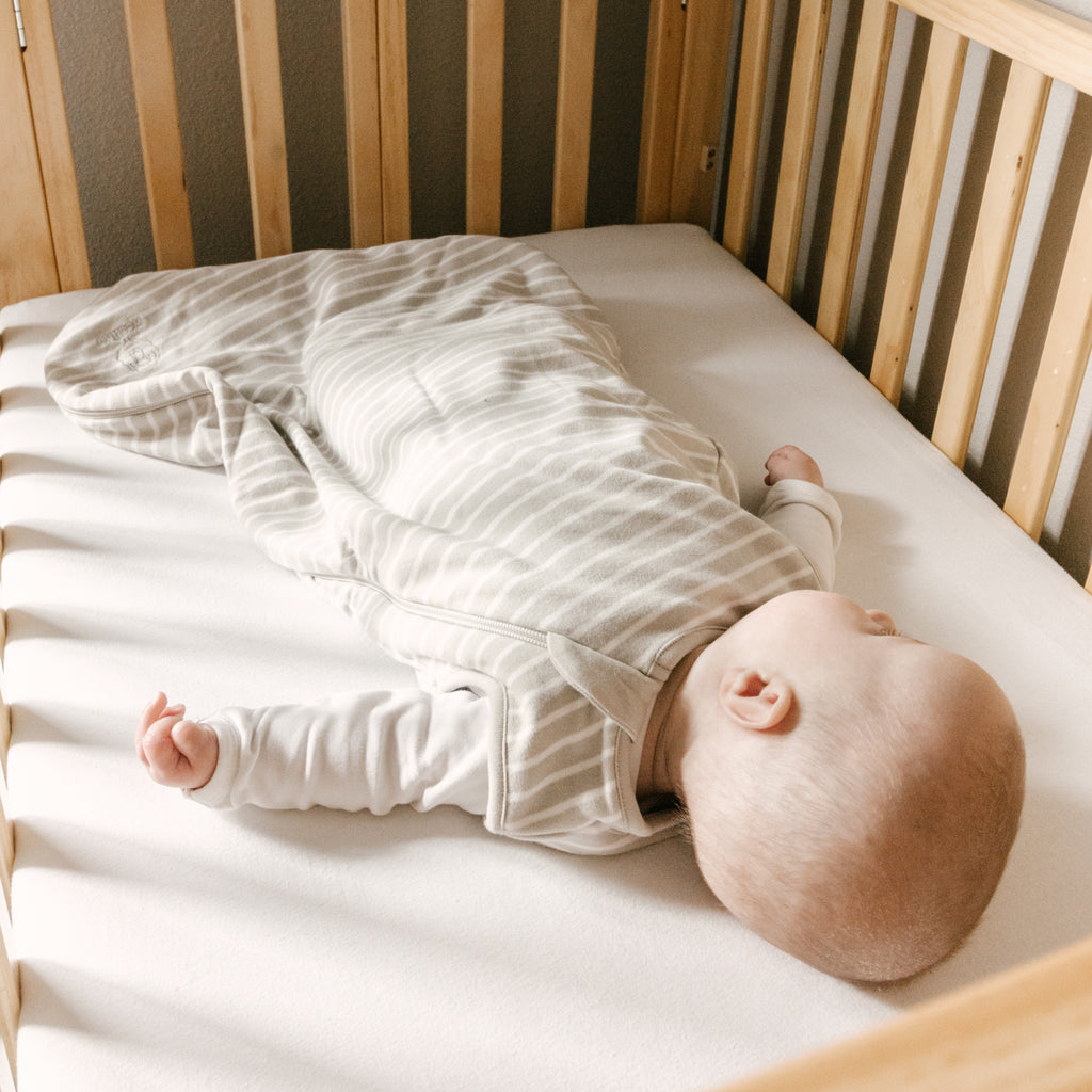 Baby sleeping on back in crib wearing a Woolino 4 Season® Basic Baby Sleep Bag