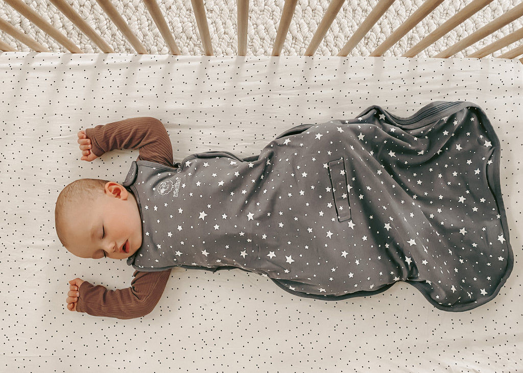 Baby sleeping on back in crib wearing a Woolino 4 Season® Ultimate Baby Sleep Bag.