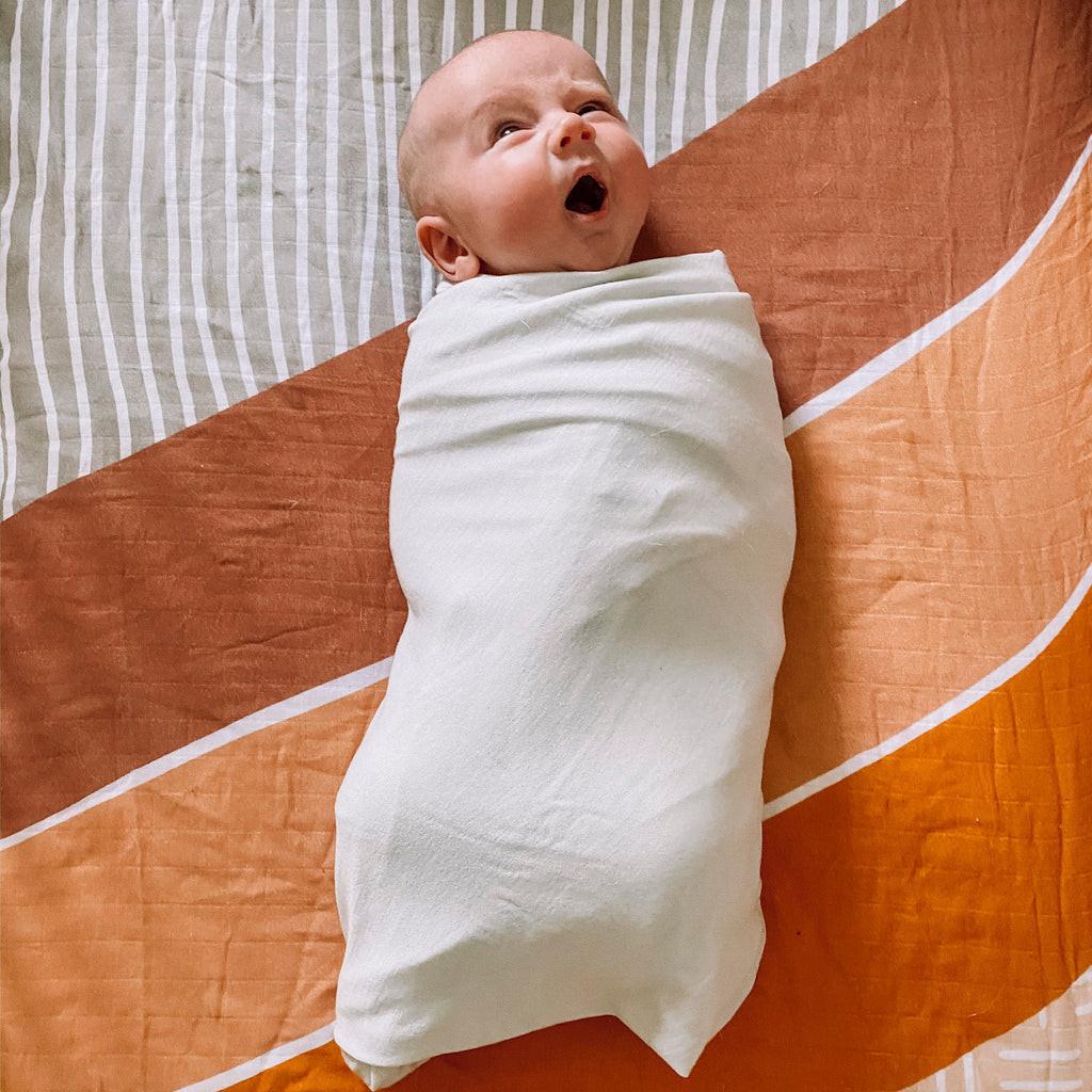 Baby yawning while swaddled in a Woolino merino wool swaddle blanket