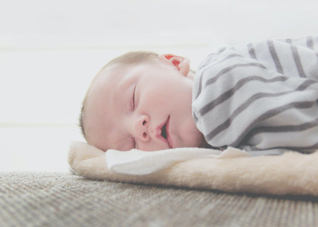 Newborn sleeping on side.