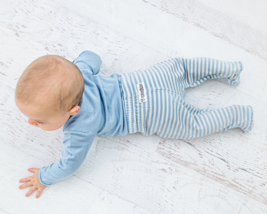 Crawling baby on tummy wearing Woolino merino wool footed pants.