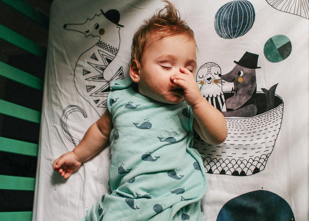 Woolino Blog: How To Help Your Congested Baby Sleep Better At Night. Congested baby sleeping in a Woolino 4 Season Ultimate Baby Sleep Bag in Whales print.