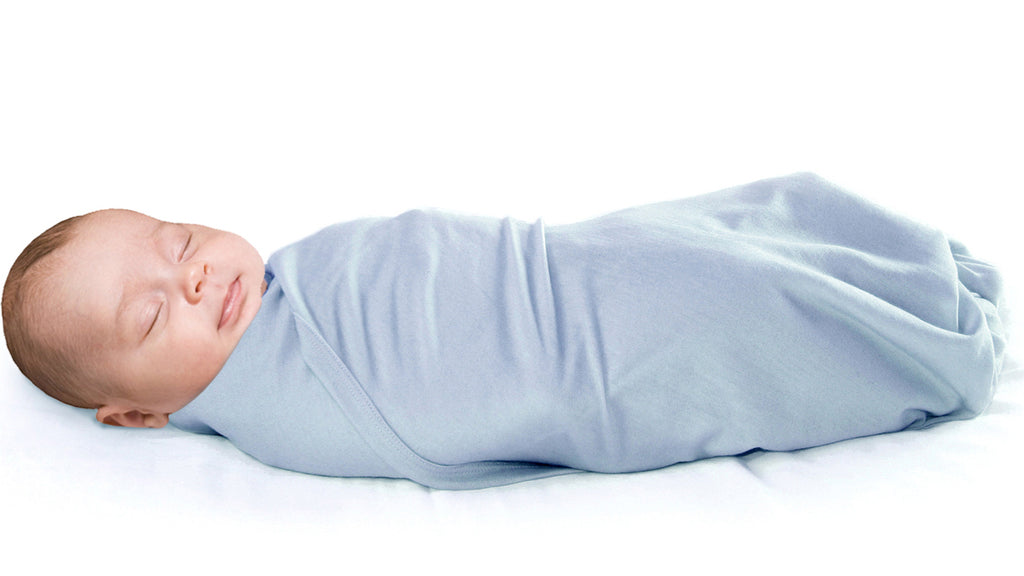 Sleeping infant swaddled in a Woolino merino wool swaddle blanket.